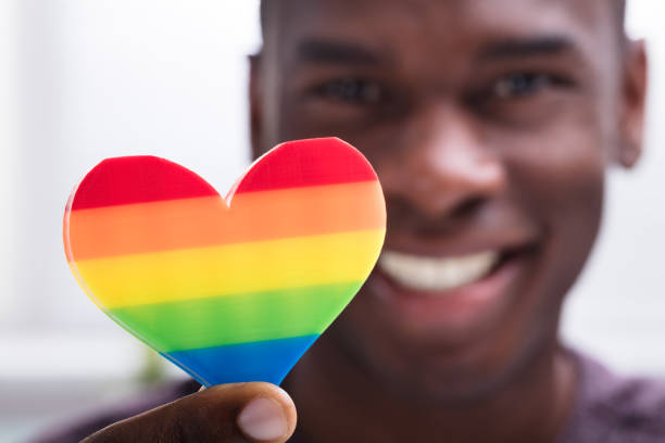 istock Smiling Man Holding Rainbow Heart In His Hand 1000963270