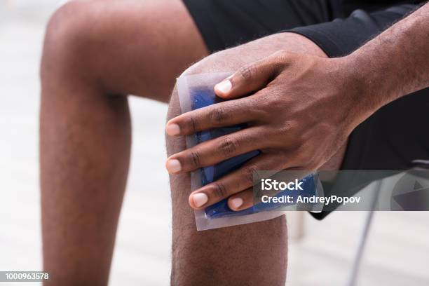 Man Applying Ice Gel Pack On His Knee Stock Photo - Download Image Now - Ice Pack, Knee, Ice