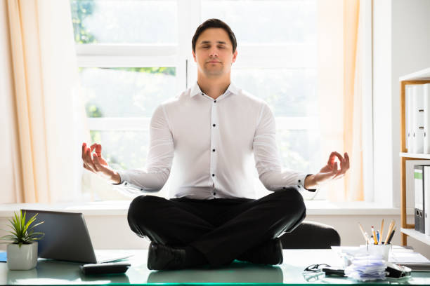 istock Businessman meditating in lotus position 1000963780