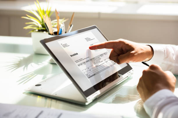 istock Businessman examining invoice on laptop 1000963840