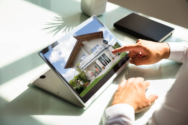 istock Businessman checking house on laptop 1000963890