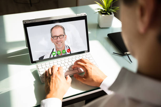Businessman videoconferencing with doctor on laptop