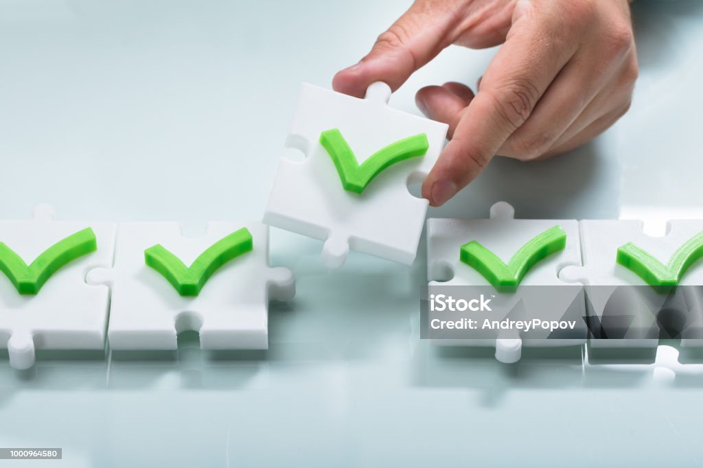 Person arranging check mark sign in a row Close-up of a person's hand arranging green check mark sign in a row Choosing Stock Photo