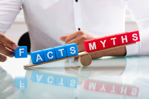 Businessman showing unbalance between facts and myths Businessman's hand showing unbalance between facts and myths on wooden seesaw unbalance stock pictures, royalty-free photos & images