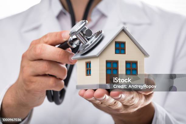 Arzt Untersucht Hausmodell Mit Stethoskop Stockfoto und mehr Bilder von Stethoskop - Stethoskop, Wohnhaus, Arzt