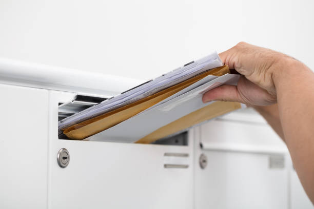 Man taking letters from mailbox Close-up of a man's hand inserting letters in mailbox full term stock pictures, royalty-free photos & images