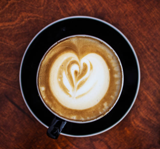Coffee mug and heart on a brown wooden table