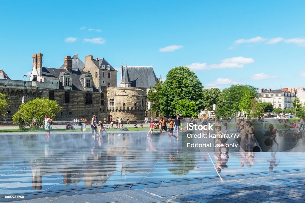 Les enfants jouent dans la fontaine en face de la forteresse à Nantes. - Photo de Nantes libre de droits