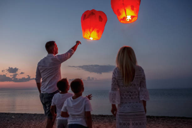 Releasing paper lanterns by the sea
