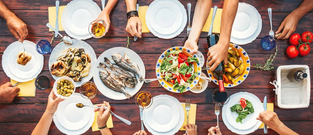 istock Big family dinner. Top vertical view on the table with dishes and hands 1000994532