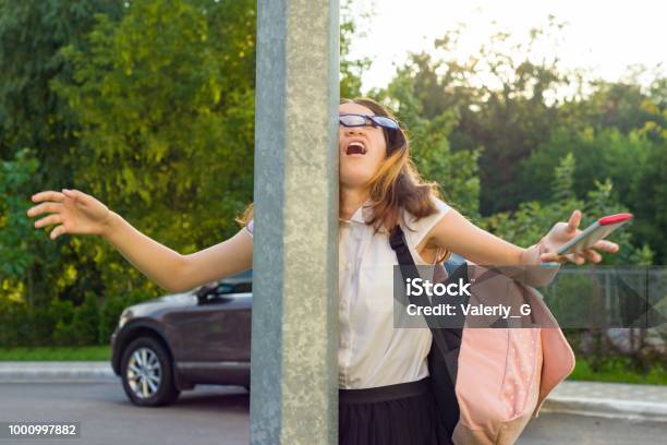 Portrait Of Young Inattentive Girl Distracted By Mobile Phone Girl Crashed Into Street Post Dropped Phone Stock Photo - Download Image Now