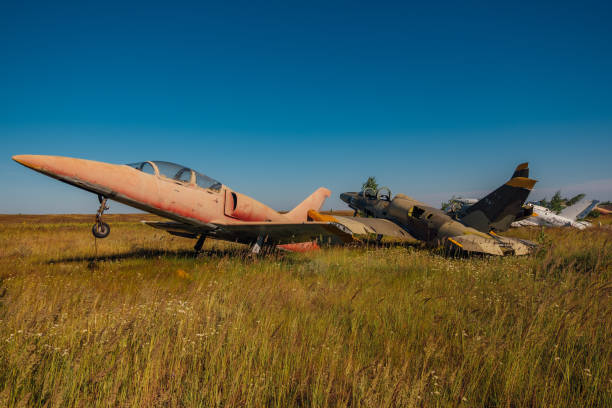 istock Abandoned broken old military fighter airplanes on grassy ground 1000997886