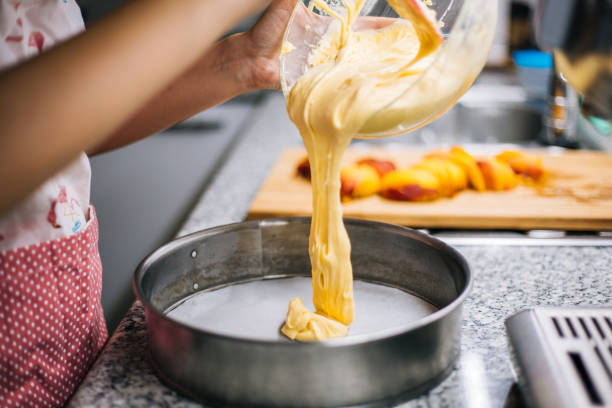 versando pastella per torte nella teglia da forno - baking flour ingredient animal egg foto e immagini stock