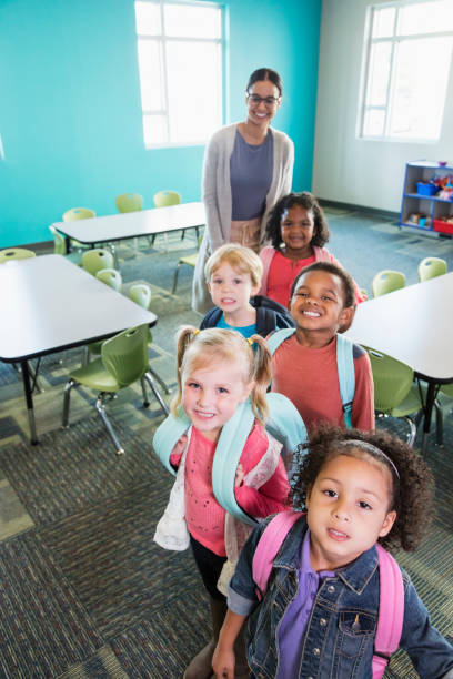 niños en edad preescolar alineados en aula con profesor - little boys preschooler back to school backpack fotografías e imágenes de stock