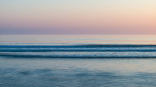 hermoso amanecer vibrante colorido sobre escena tranquila del paisaje de la playa de bajamar - bamburgh northumberland england beach cloud fotografías e imágenes de stock
