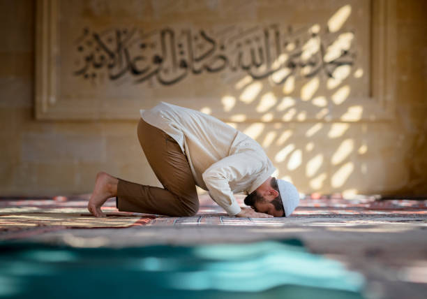 Muslim man is praying in mosque stock photo