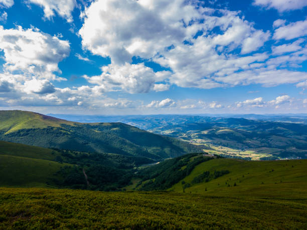 istock Beautiful big green mountain valley against a blue sky with white clouds 1001021942