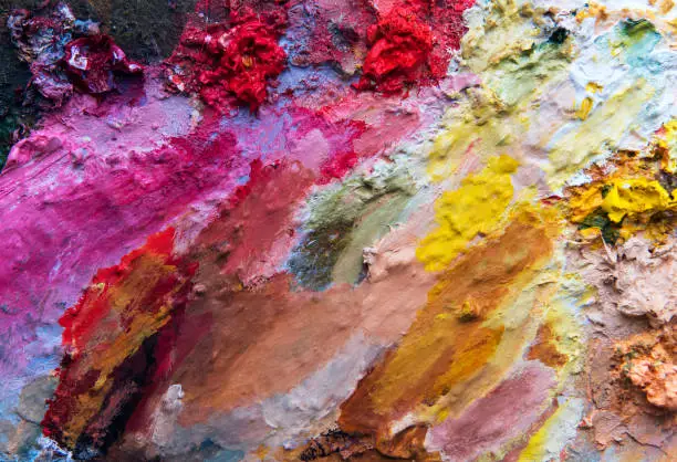 Background image of bright oil-paints mixed in the palette