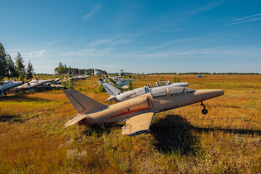 Abandoned broken old Soviet military fighter airplanes on grassy ground.