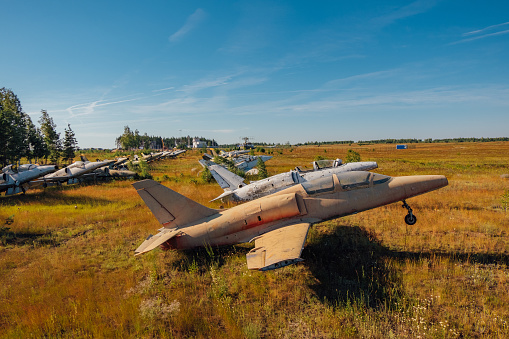 Abandoned broken old Soviet military fighter airplanes on grassy ground.