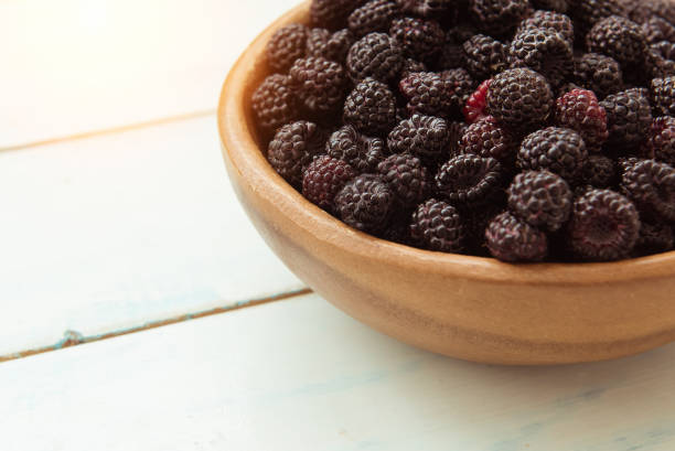 istock Ripe fresh blackberries in a wooden bowl on the table 1001106926