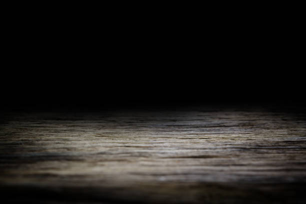istock Wood table and black wall background, Empty wooden floor space platform with library background for product display. 1001114446