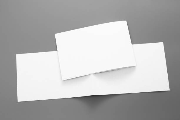 istock Blank portrait A4. brochure magazine isolated on gray, changeable background / white paper business card isolated on gray 1001114772