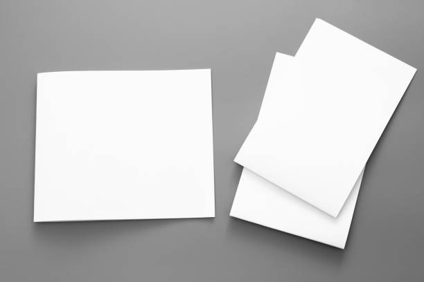 istock Blank portrait A4. brochure magazine isolated on gray, changeable background / white paper business card isolated on gray 1001114794