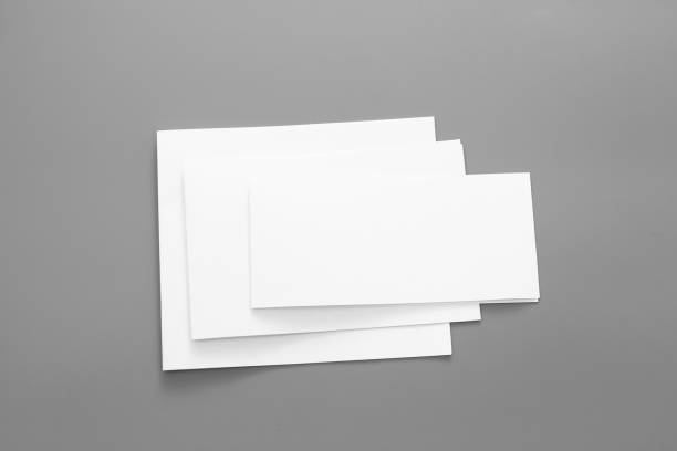 istock Blank portrait A4. brochure magazine isolated on gray, changeable background / white paper business card isolated on gray 1001115048