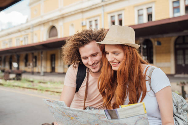 istock Young couple looking at the map at the railway station 1001117628