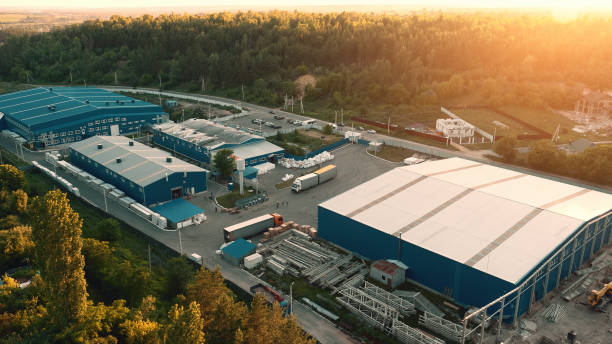 vista aerea degli stoccaggi di magazzino o della fabbrica industriale o del centro logistico dall'alto. veduta aerea degli edifici industriali al tramonto - plant facility foto e immagini stock