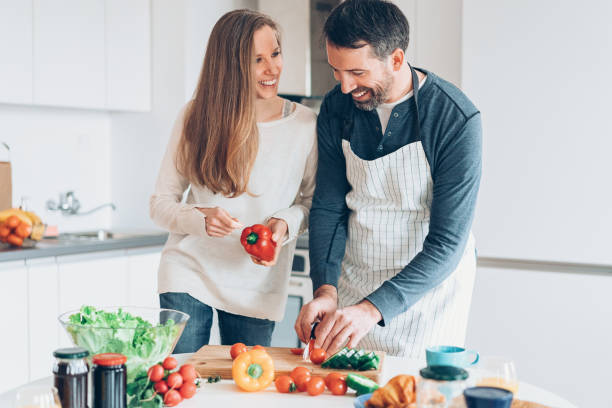 istock Happy couple making salad in the kitchen 1001121574