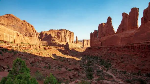Morning shadows cast into the Park Avenue Trail in Arches National Park