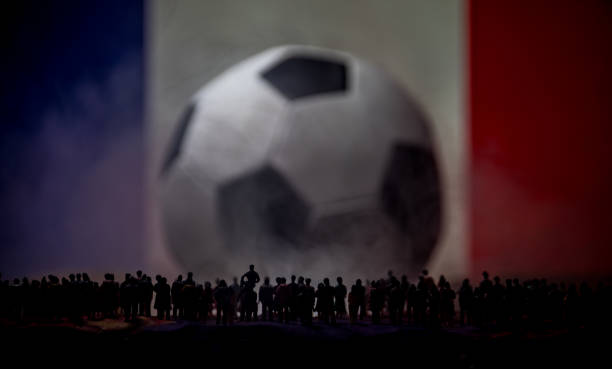 Silhouette Crowd at a big blurred soccer ball. Creative concept. Selective focus