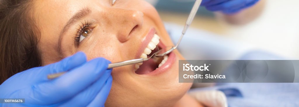 Woman at the dentist Dentist checking teeth of young happy patient in dentist's office. Dentist Stock Photo