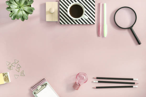 istock Creative desk with office accessories, cup of coffe, notes and plant. Pink background with copy space for inscription. Back to school. 1001151338