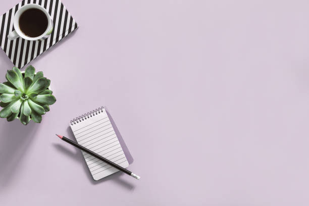 istock The top view of creative desk with office accessories, succulent and notes. Pink background with copy space for inscription. Back to school. Minimalistic composition. 1001153466