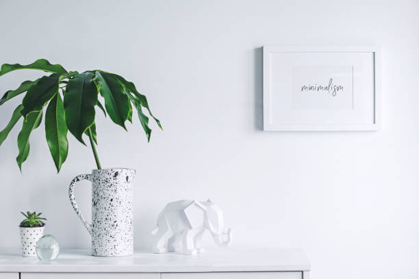 istock Stylish and modern white interior with mock up frame , cacti and elephant figures. White concept of cupboard shelf. 1001156680