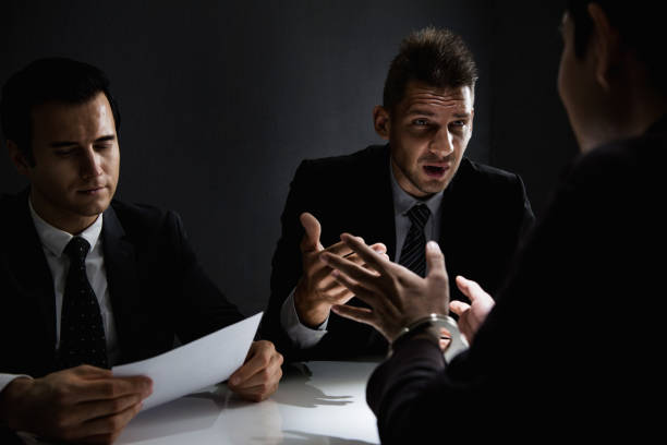 Criminal man being interviewed in interrogation room after committed a crime