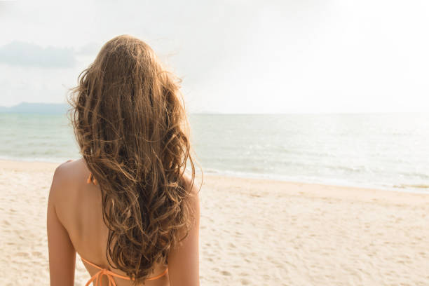 schöne frau am tropischen strand im sommer - women long hair rear view beauty stock-fotos und bilder