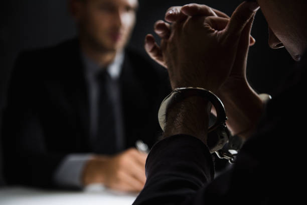 istock Criminal man with handcuffs in interrogation room 1001168248
