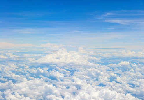 Beautiful view of blue sky above the white clouds from airplane window.