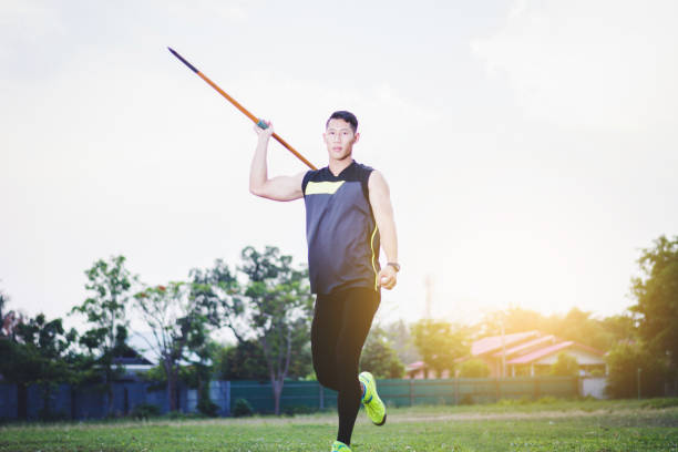 istock sportsman warming up and practicing javelin throw in yard 1001233598
