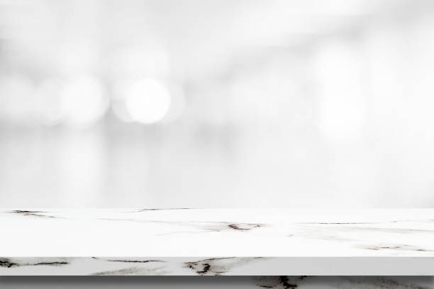 istock Empty white marble table over blur store background, product display montage 1001239910