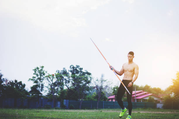 sportsman warming up and practicing javelin throw in yard