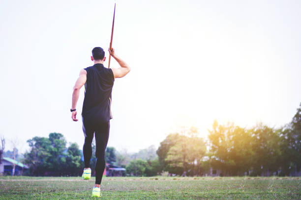 istock sportsman warming up and practicing javelin throw in yard 1001259356