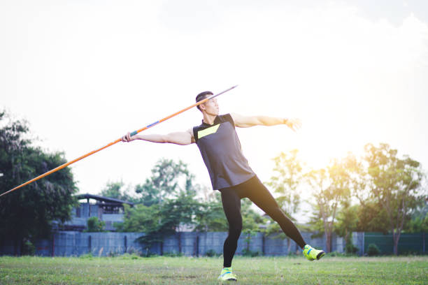 istock sportsman warming up and practicing javelin throw in yard 1001261324