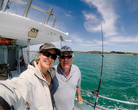 Selfie: father and daughter male and female caucasian tourists on fishing charter vessel in Far North District, Northland, New Zealand, NZ