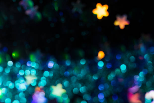 blurred seamless pattern with colorful metallic stars, dark blue background, selective focus