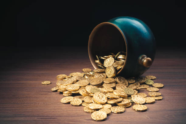 Green pot of gold on top of gold coins stock photo
